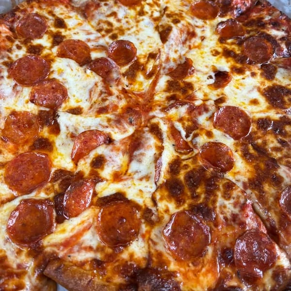 Close-up of a freshly baked pepperoni pizza with melted cheese and crispy edges.