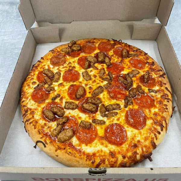 A whole pepperoni and sausage pizza in an open cardboard box from Bob's Pizza.